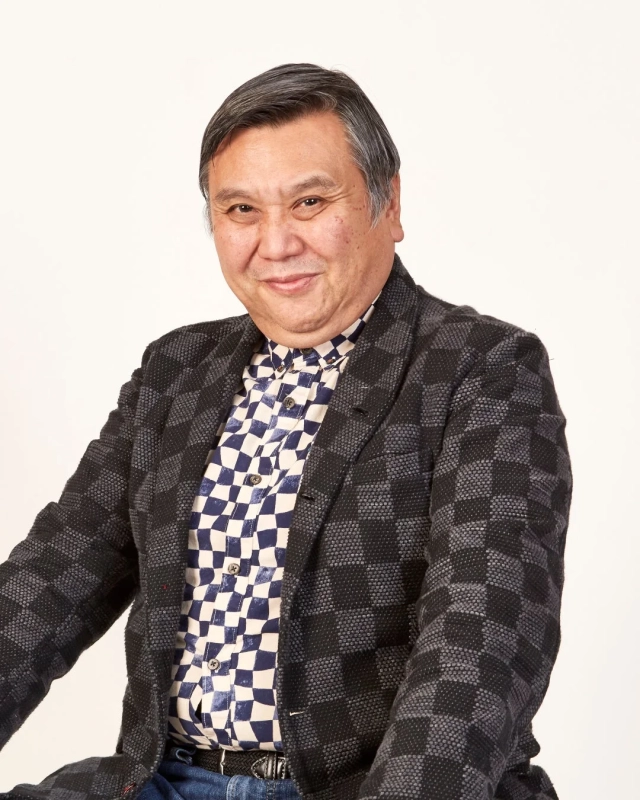 笑顔でカメラを見つめる中高年のアジア人男性