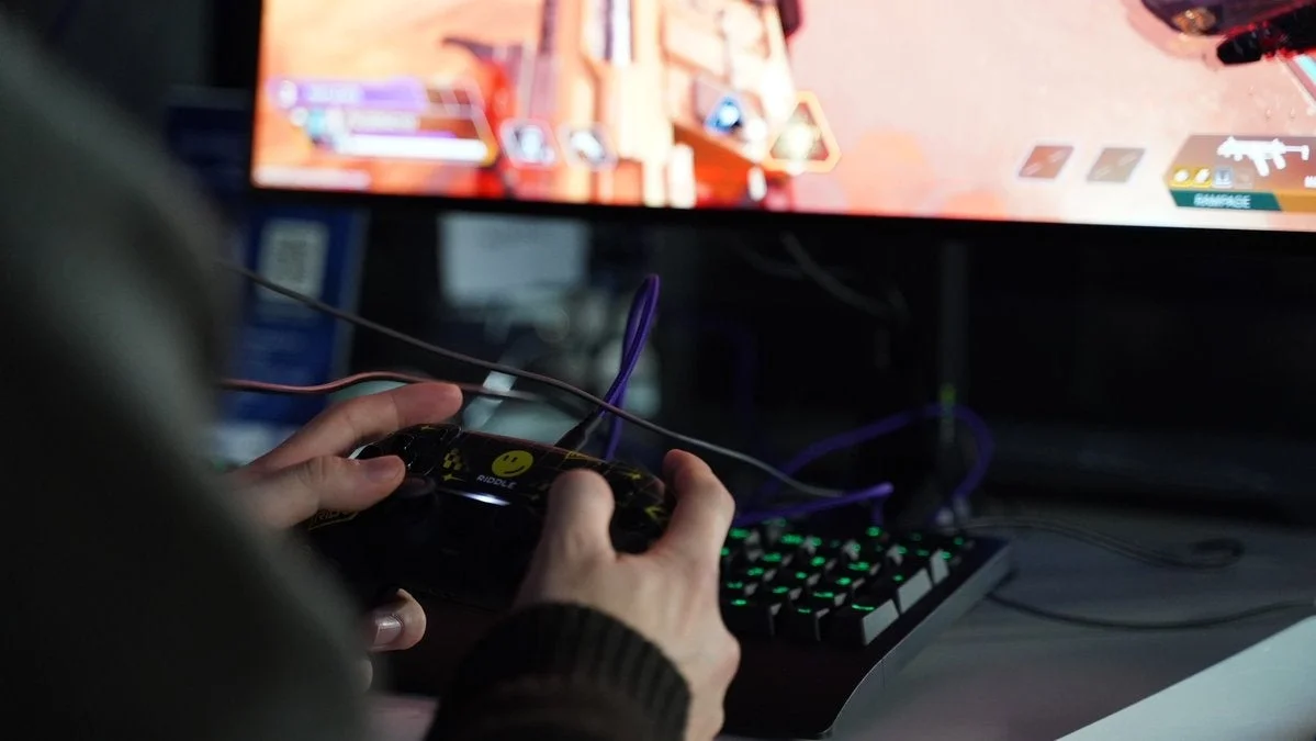 モニターの前でコントローラーを操作してビデオゲームをプレイしている人物