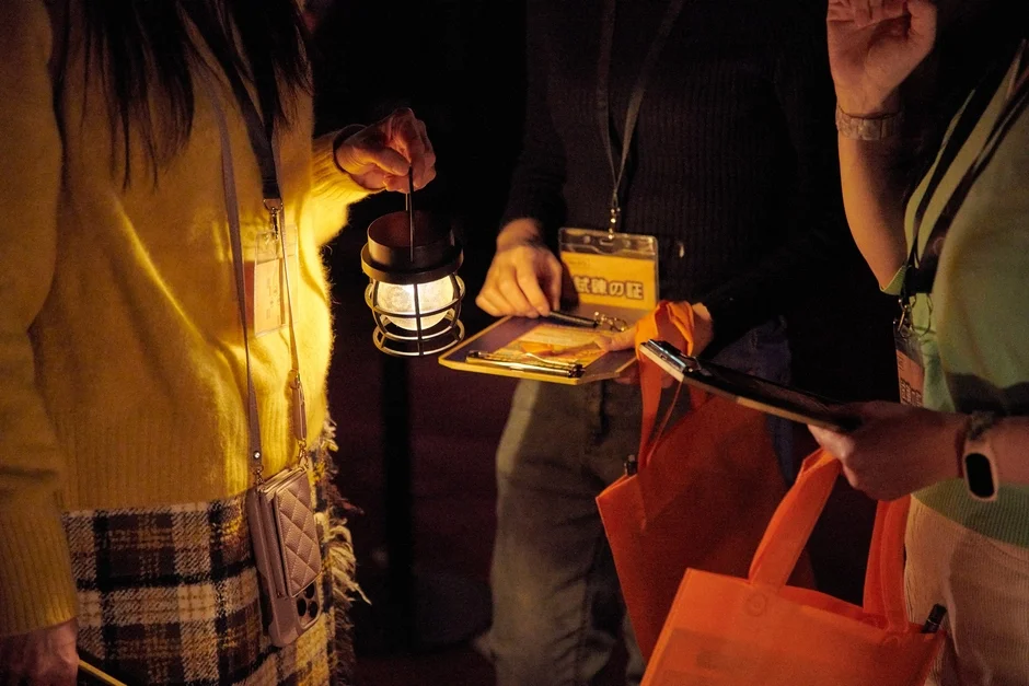 ランタンを手にクリップボードで何かを確認している人々