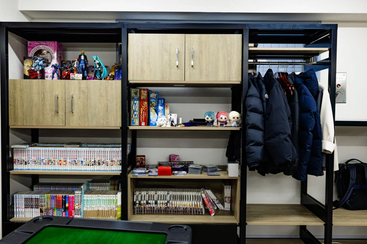 フィギュアや漫画、ボードゲームが並ぶ棚と麻雀卓