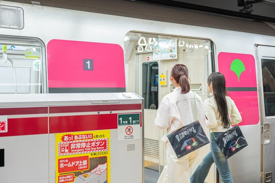 電車のホームに立つ女性たち、非常停止ボタンの案内