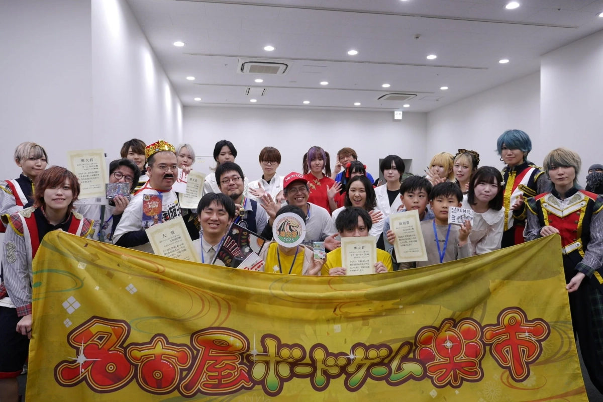 「名古屋ボードゲーム楽市」の集合写真、多くの参加者が賞状を持ち笑顔でイベントの成功を祝っている