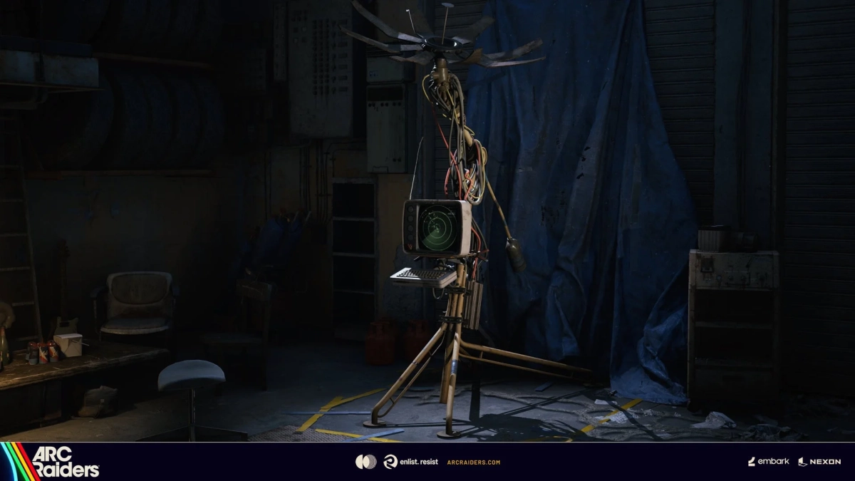 暗いガレージのような空間に、レトロなモニターとアンテナ、大量の配線で構成された手作りのような装置