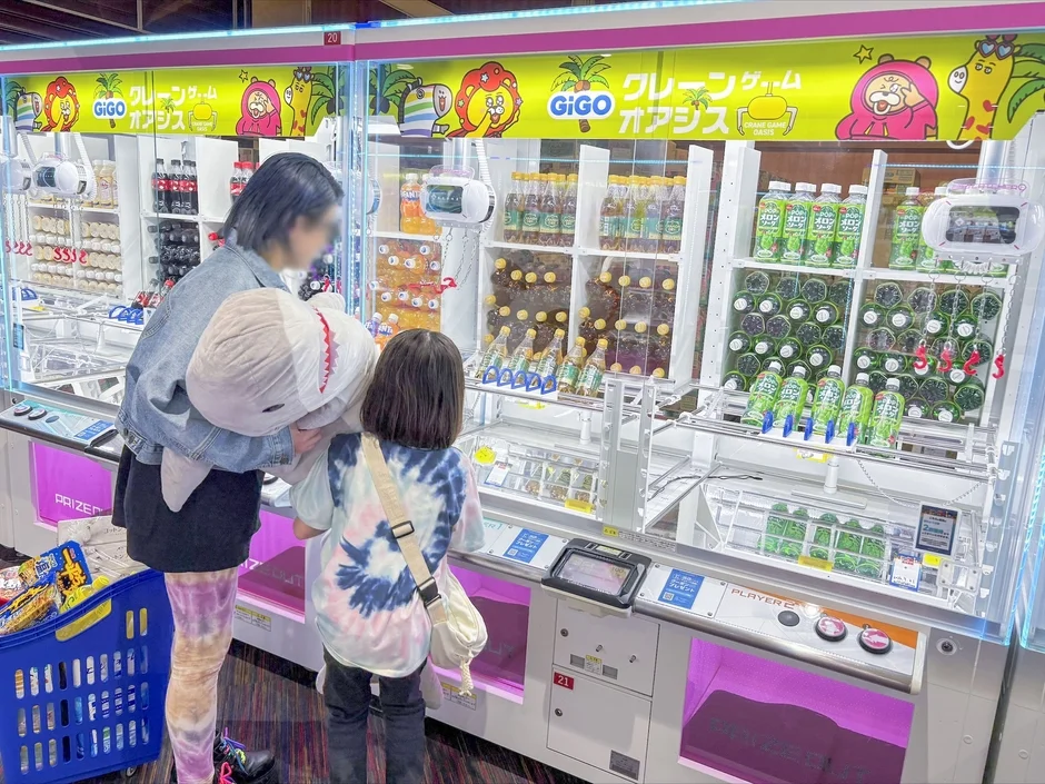 クレーンゲームで遊ぶ親子と景品