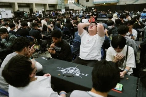 多くの人々がスマートフォンに没頭しているシャドウバース大会会場の様子