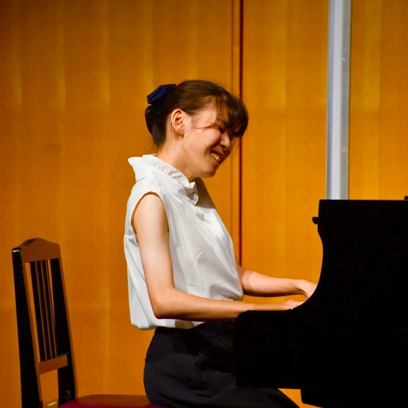 ピアノを笑顔で演奏する女性