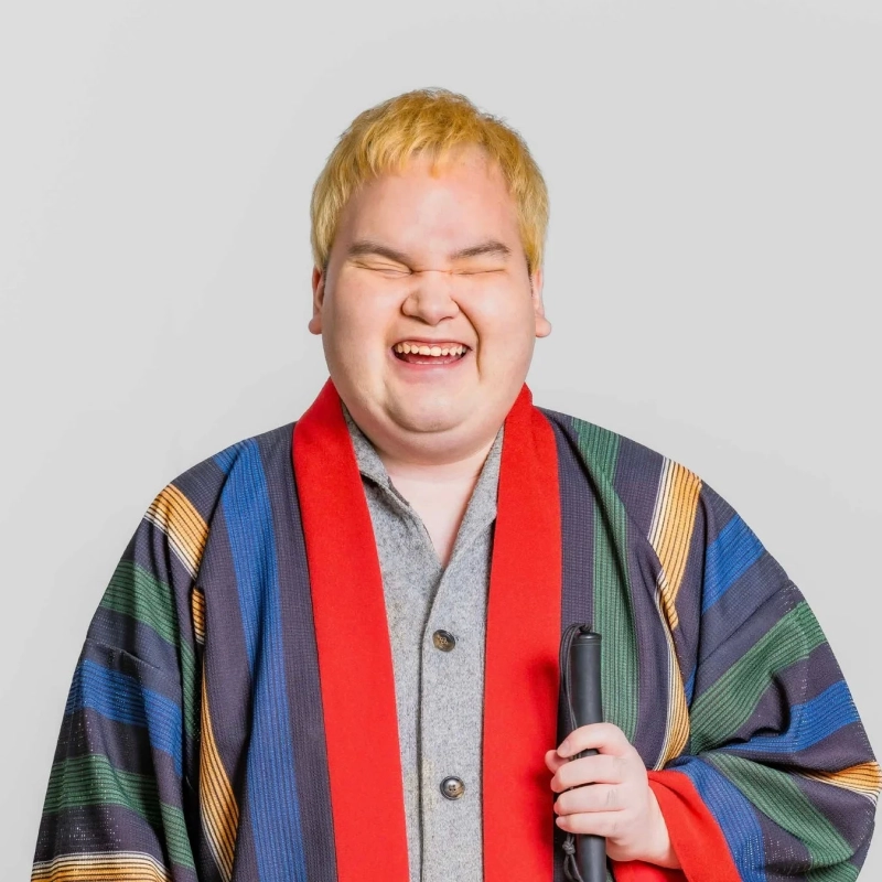 金髪の男性が笑顔で笑っているポートレート