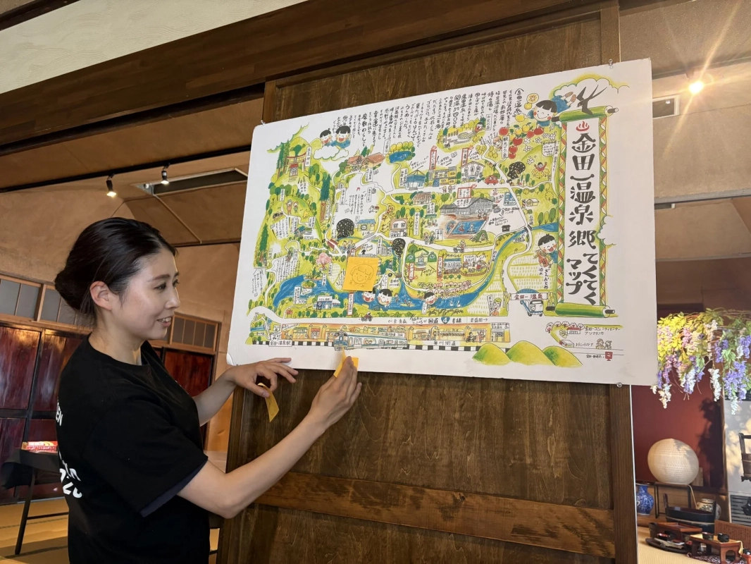 金田一温泉郷マップを指差す女性