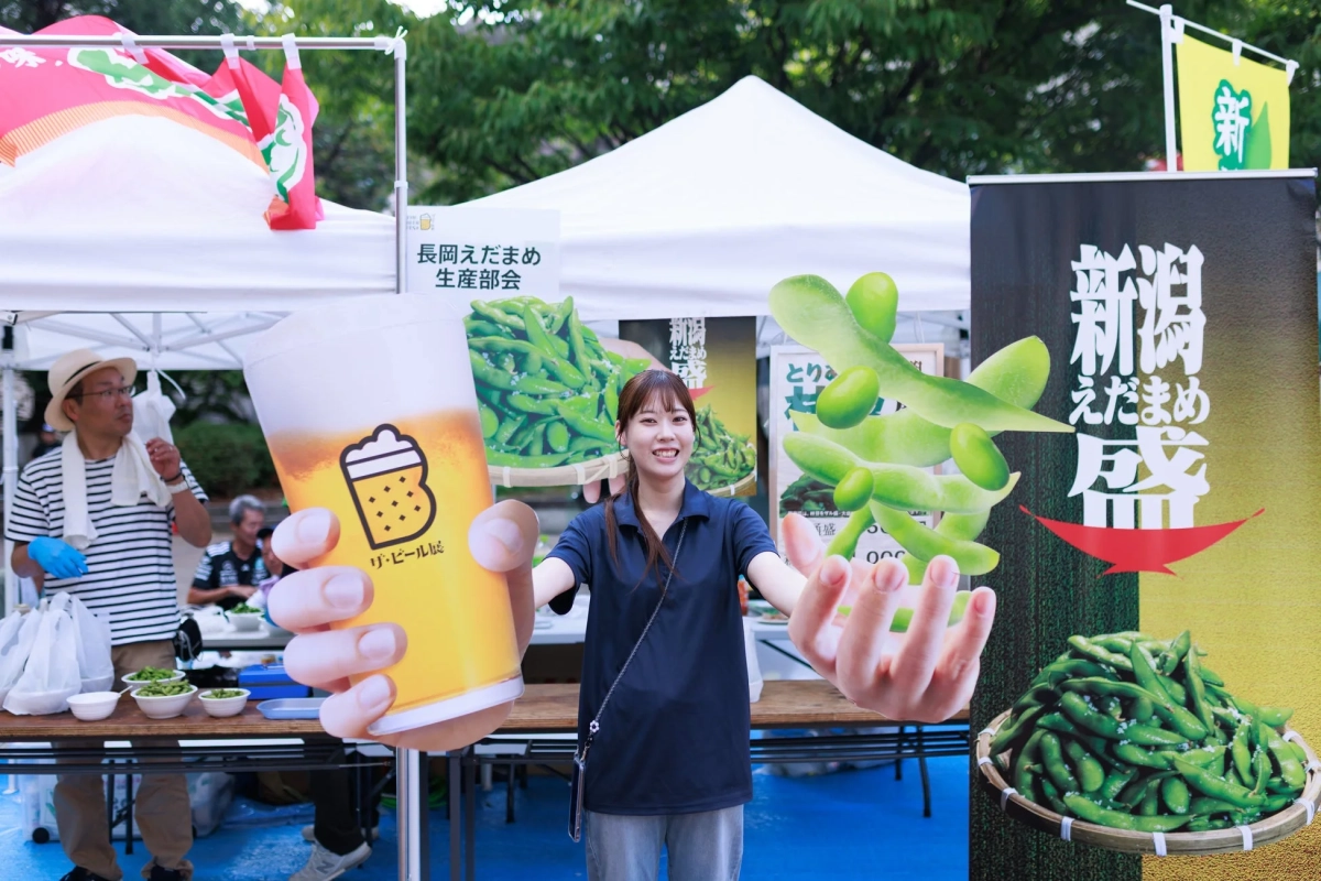 枝豆とビールの看板を持つ女性