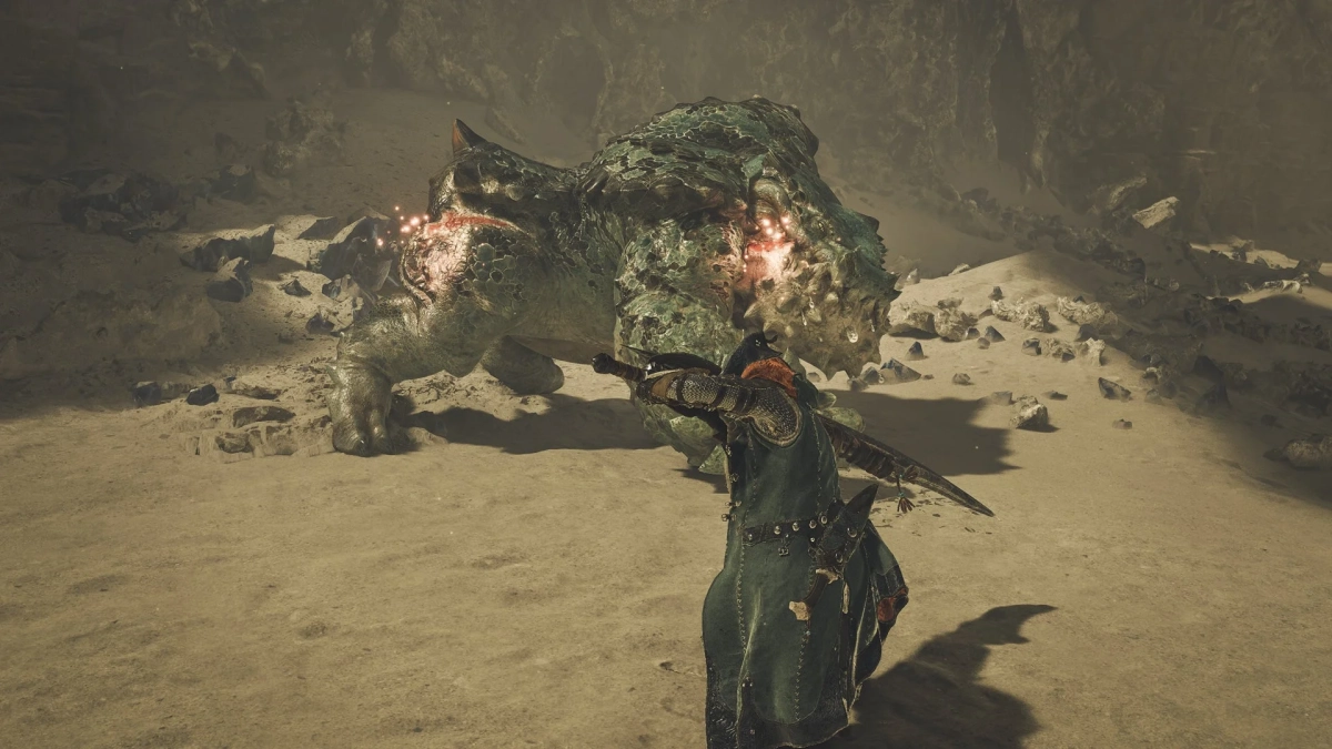 岩場で巨大なモンスターと戦うハンター