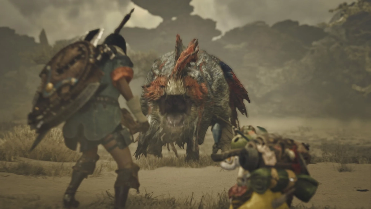 砂漠で巨大なモンスターと戦うハンター