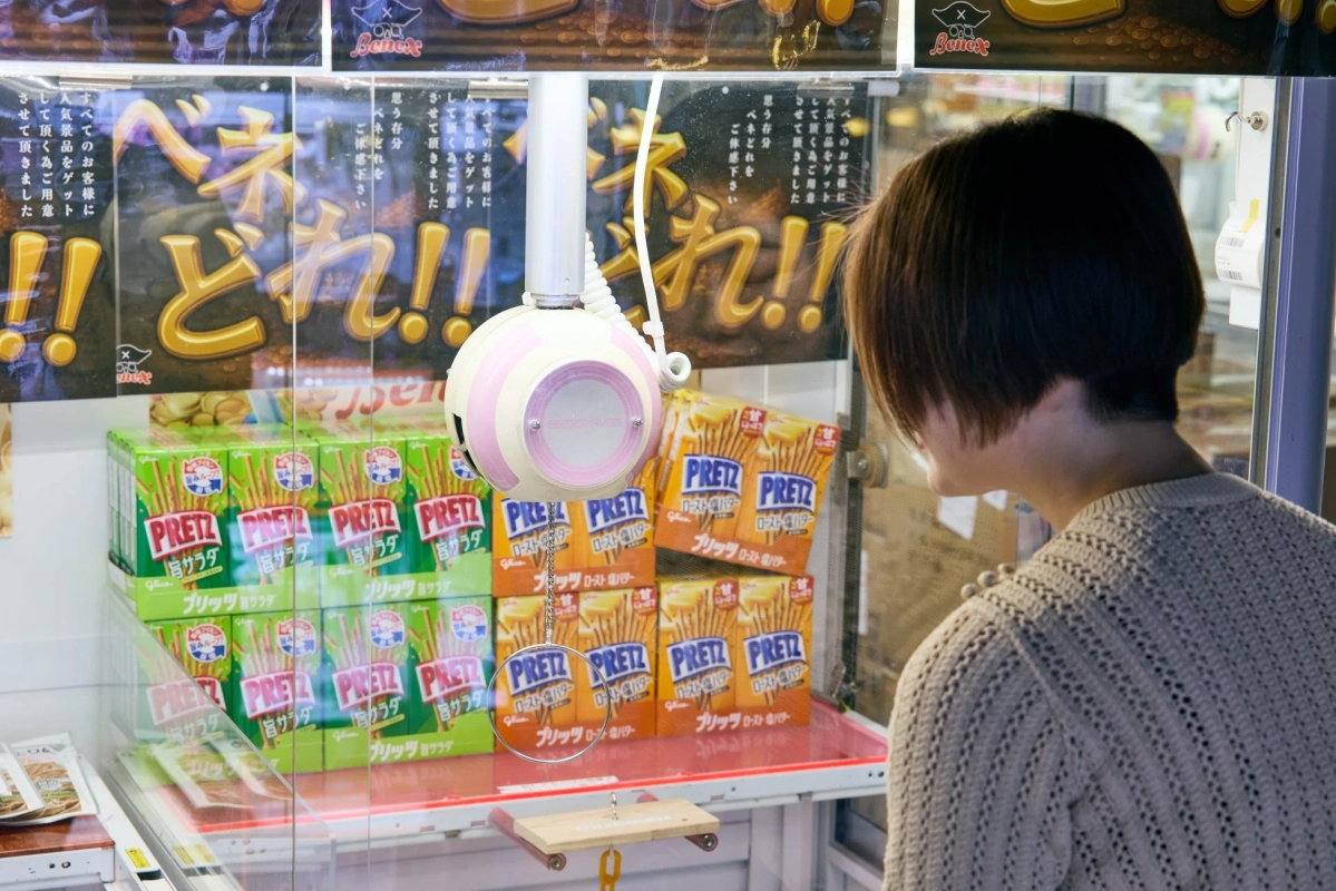 プリッツを狙う女性のUFOキャッチャー画像