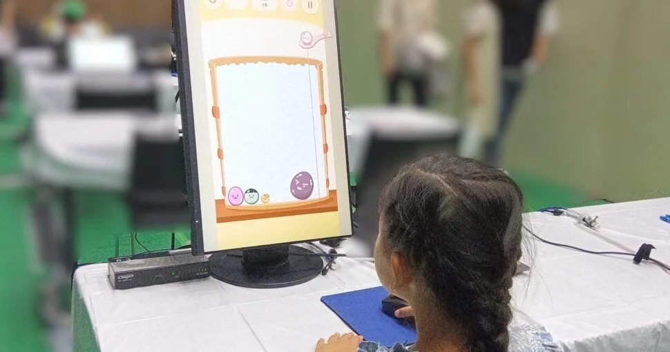 子供がコンピューターのモニターに向かい、マウスを操作している様子