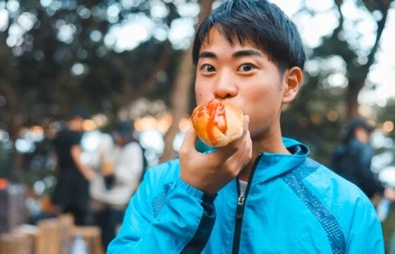 屋外でホットドッグを食べる男性