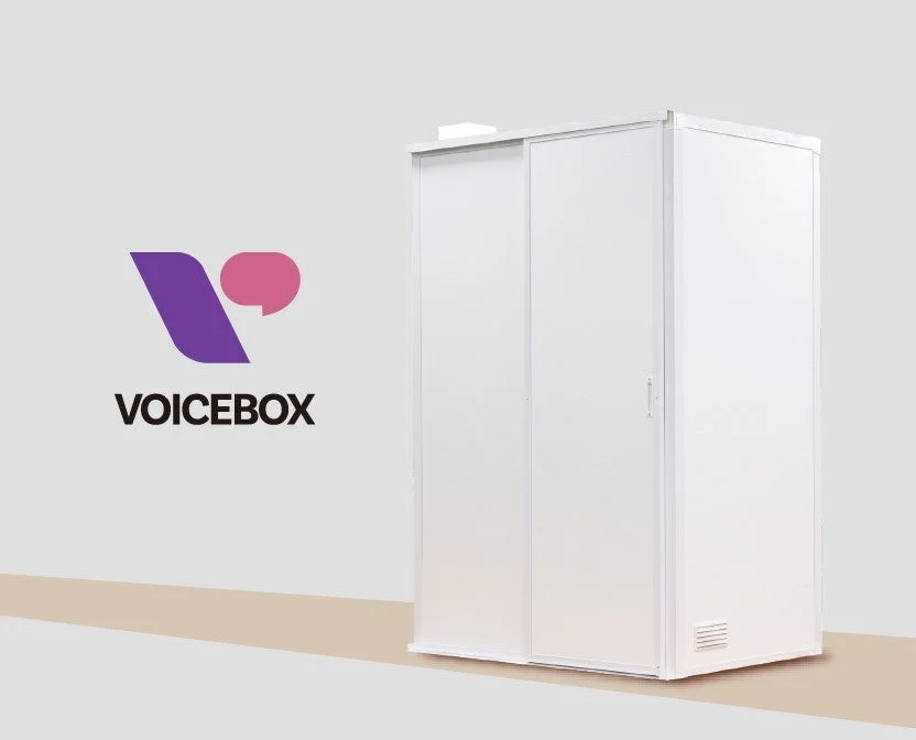 VOICEBOXのロゴが配置されたシンプルな背景に、モダンなデザインの白い防音ブース