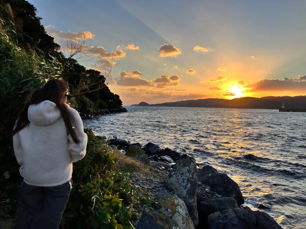 夕焼けの海を眺める女性