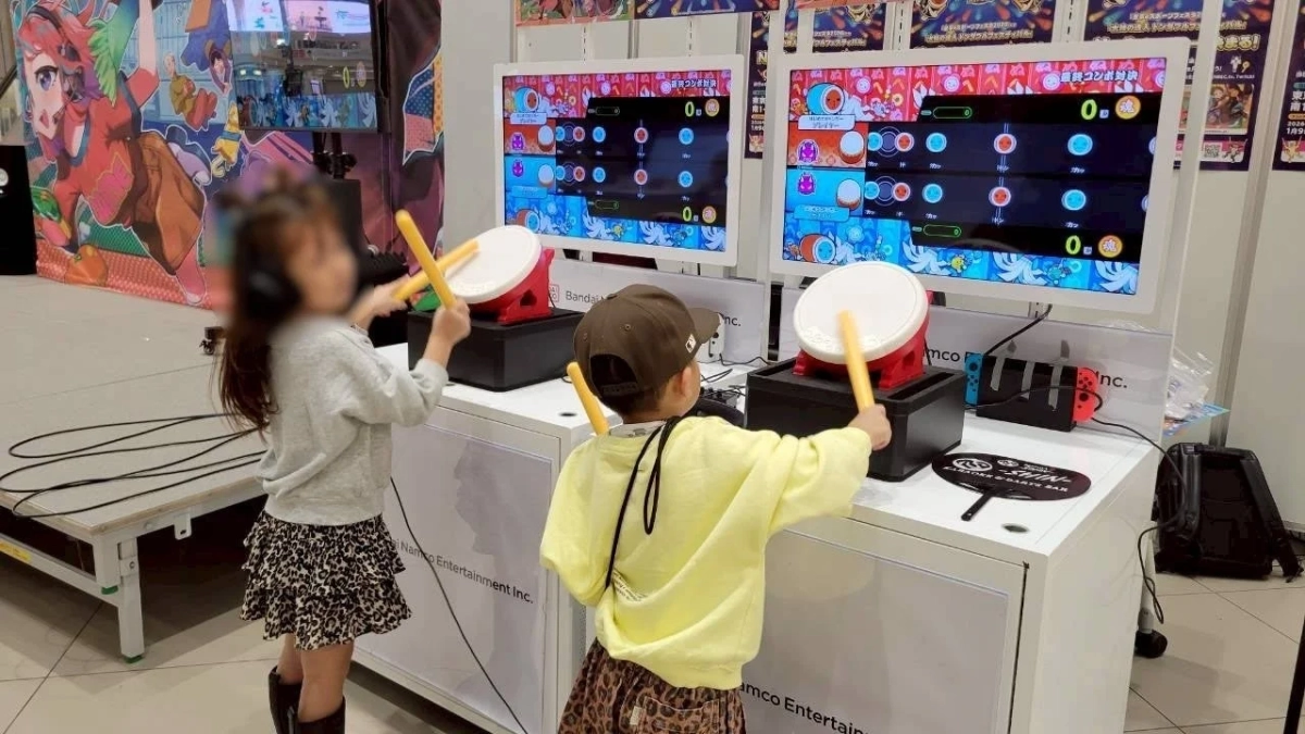 太鼓の達人のような音楽ゲームに熱中する子供たち